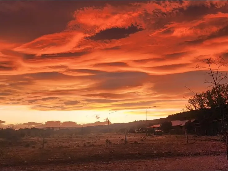 Cielo naranja al atardecer sobre el campo